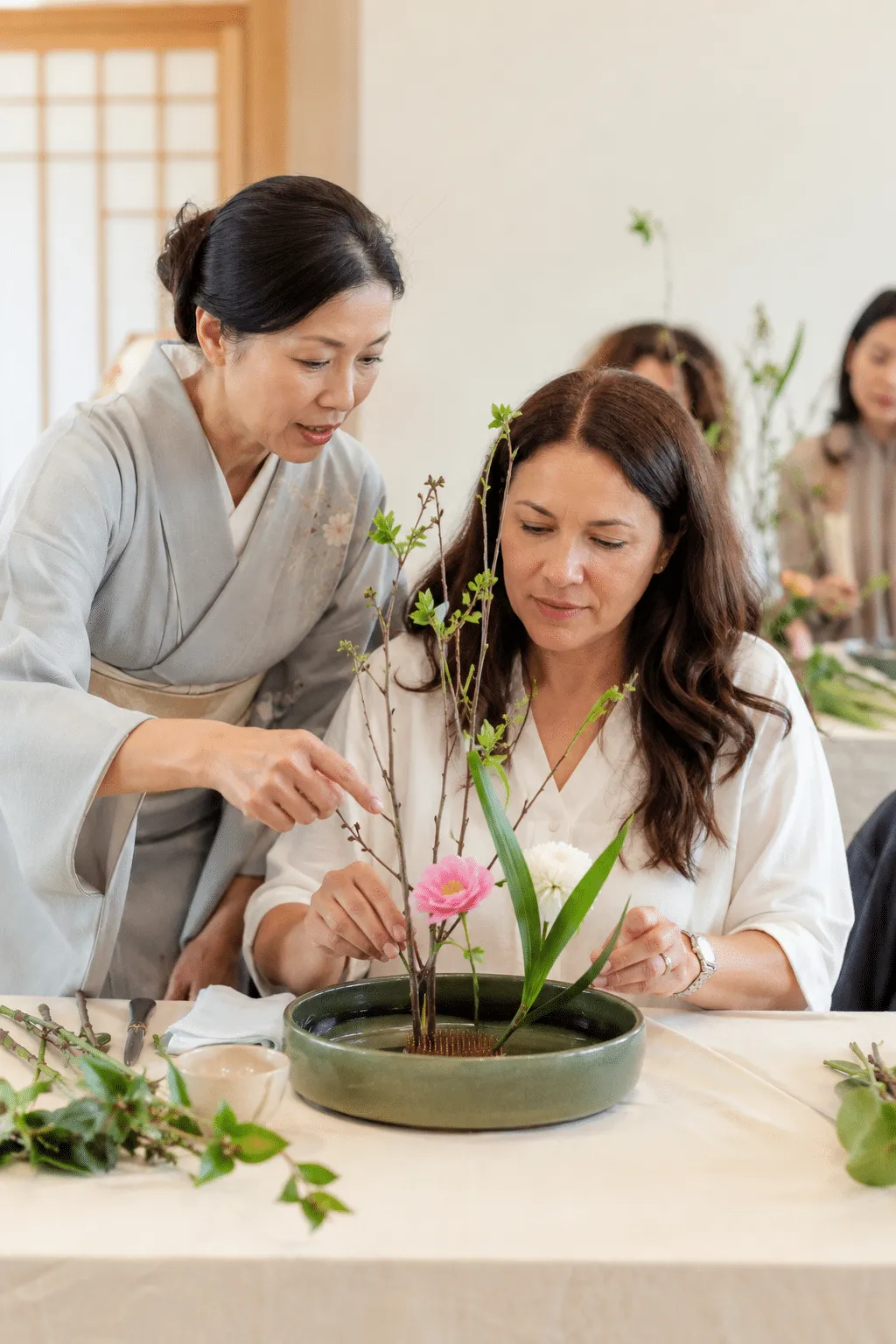 An instructor guiding a participant through an Ikebana arrangement